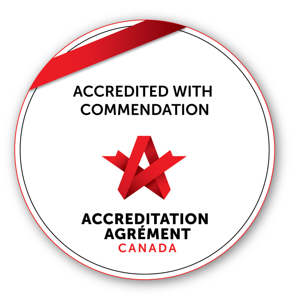 A round badge with a red ribbon and text stating "Accredited with Commendation" and "Accreditation Agrément Canada" above and below a red abstract logo.